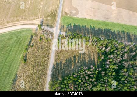 aerial view of dirt road between fields and forest. agricultural landscape. drone photography. Stock Photo