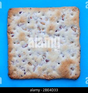 Square salted cracker on blue background - top view closeup Stock Photo