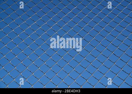 Wire mesh fence and a restricted area sign with blue sky background Stock Photo