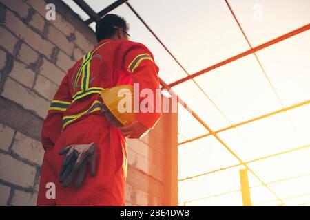 Engineer holding helmet at construction site Stock Photo