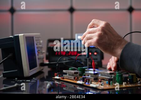Debugging electronics device. PCB witch microcontroller in electronics laboratory Stock Photo