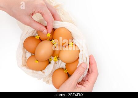 Eggs and flowers. Close up composition on white background, woman hands. Holidays, Easter eggs concept Stock Photo