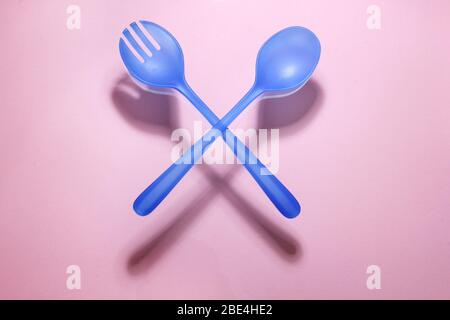 Plastic Fork and Spoon on Pink Background Stock Photo
