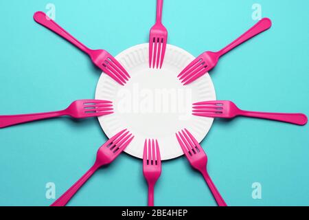 Paper Plate and Plastic Forks on Blue Background Stock Photo