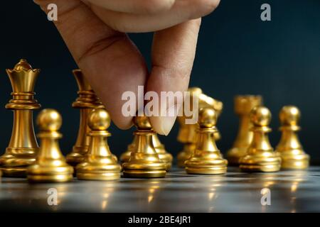 Business man hold pawn to move in chess game on black background (Concept for company strategy, vision or decision) Stock Photo