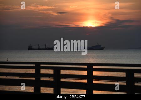 Ahlbeck, Germany. 12th Apr, 2020. Clouds move in the early morning hours during sunrise in the sky above the pier on the island of Usedom. The 280m long pier was already opened in 1898 and is the oldest pier in Germany. Credit: Stefan Sauer/dpa/Alamy Live News Stock Photo