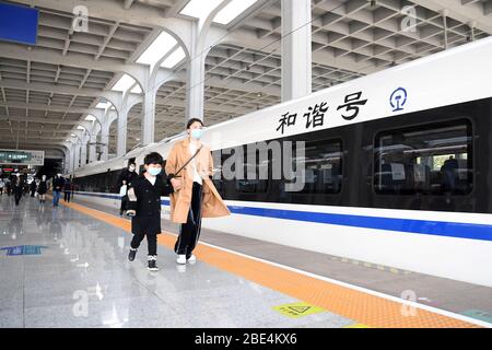 Chongqing, China. 12th Apr, 2020. Passengers prepare to board the first train from Chongqing in the high-speed rail loop that connects southwest China's major cities at Chongqing West Railway Station in southwest China's Chongqing Municipality, April 12, 2020. A high-speed rail loop that connects major cities in China's southwestern region started operation on Friday, according to the local railway operator. The route, extending 1,290 km, connects Chengdu, capital of Sichuan Province, Chongqing Municipality, and Guiyang, capital of Guizhou Province. Credit: Xinhua/Alamy Live News Stock Photo