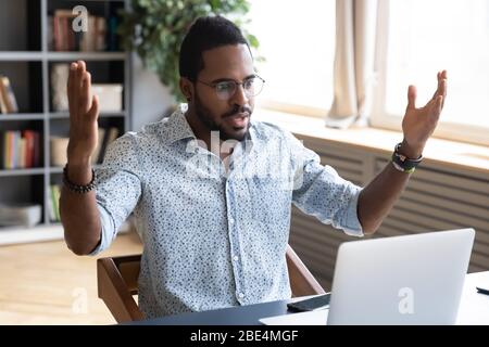 Frustrated young biracial man feeling shocked about online news. Stock Photo