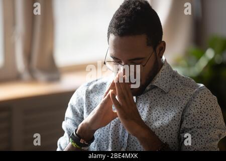 Thoughtful young mixed race man feeling complicated about hard decision. Stock Photo