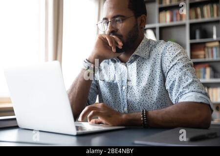 Thoughtful millennial biracial man in eyeglasses stack with hard task. Stock Photo