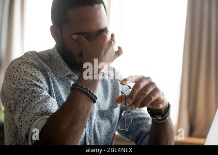 Exhausted african ethnicity man having problems with vision. Stock Photo