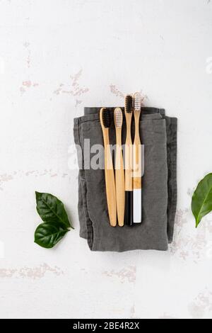 Organic bamboo toothbrushes on light surface, green living concept Stock Photo