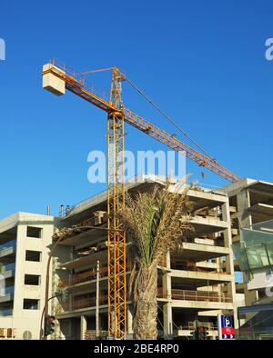 High rising crane at a building site of a new block of flats and offices. Heraklion, Crete, Greece. Concept: building construction. Stock Photo
