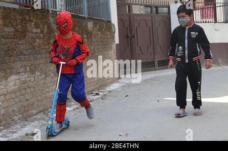 Kathmandu, Nepal. 12th Apr, 2020. Student Aaramva Shrestha wearing a  spiderman costume plays with his friend during the nationwide lockdown in  Kathmandu, Nepal on April 12, 2020. Most of the Nepali students