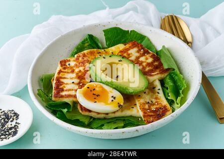 keto ketogenic diet soft boiled eggs with avocado and lettuce on pastel background closeup Stock Photo
