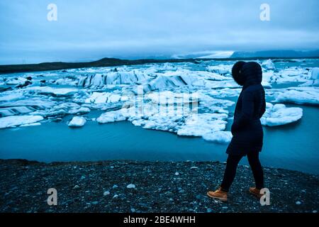 A female traveler looking at the Jokulsarlon Glacial Lagoon Stock Photo
