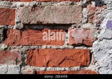 red brick wall detail with damaged plaster Stock Photo