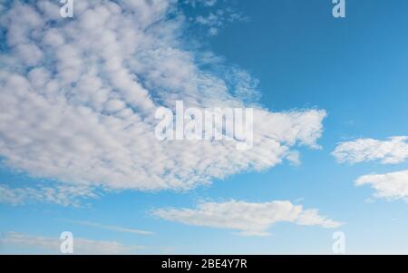 white cirrus, feathery clouds  against spring bright blue cloudy sky  on sunny day in England Stock Photo