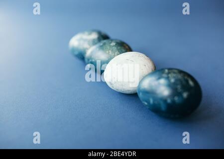 Beautiful group ombre blue Easter eggs with quail eggs and feathers on a blue background. Easter concept. Border eggs. Copy space for text Stock Photo