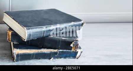 three old shabby books lying on the table indoor closeup Stock Photo