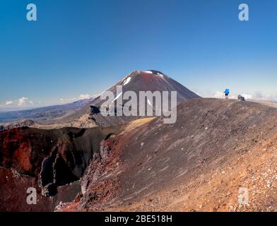 Backpacker looking at Mt Ngauruhoe (aka Mt Doom) and Red Crater in New Zealand’s Tongariro national park. Stock Photo