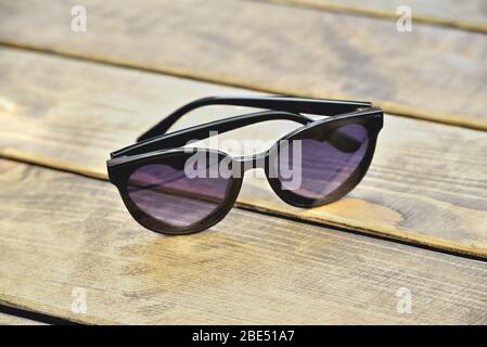 Sunglasses with glasses in the form of hearts on a wooden background, concept close-up Stock Photo