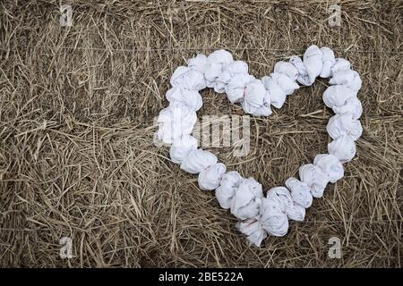 White rag heart on a straw background Stock Photo