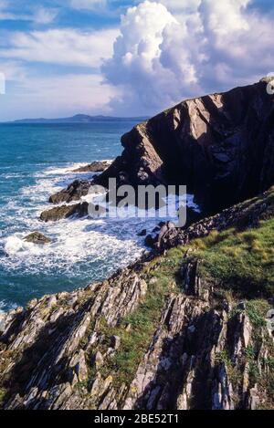 View of sea and sea cliffs near Porth Gain on a sunny summer day with dramatic clouds. Taken from the Pembrokeshire Coastal Path, Wales, UK. Stock Photo