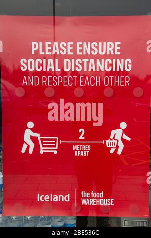 Cumbernauld, UK. 12th Apr, 2019. Pictured: Shop sign advising customers on social distancing. Scenes during the Coronavirus (COVID-19) lockdown from a retail park in Cumbernauld. Shoppers queue outside to get their bargains and supplies for the Easter Sunday festive period. Credit: Colin Fisher/Alamy Live News Stock Photo