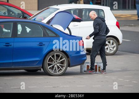 Cumbernauld, UK. 12th Apr, 2019. Pictured: A man buys 2 tubs of paint. Scenes during the Coronavirus (COVID-19) lockdown from a retail park in Cumbernauld. Shoppers queue outside to get their bargains and supplies for the Easter Sunday festive period. Credit: Colin Fisher/Alamy Live News Stock Photo