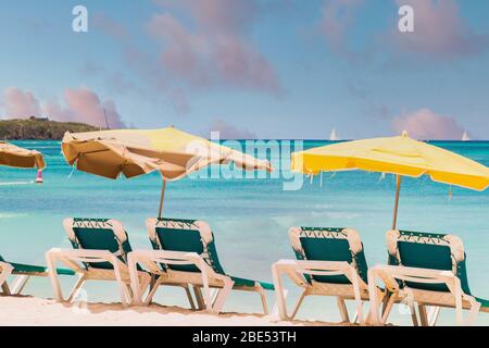 Chaise Lounges with Sun Umbrellas on a Beautiful Tropical Beach Stock Photo