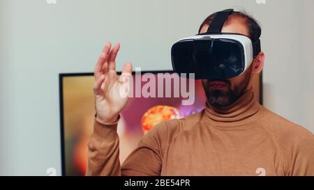 Engineer wearing virtual reality headset in home office to develop modern gearing technology. Stock Photo