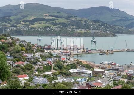 LYTTLETON, NEW ZEALAND - December 02 2019: aerial cityscape with cranes and cargo on harbor quays, shot in bright cloudy light on december 02 2019 at Stock Photo