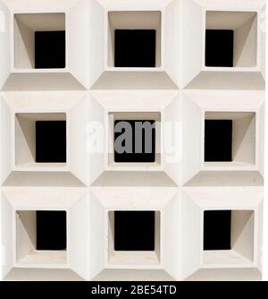 Square openings in a curved concrete wall Stock Photo