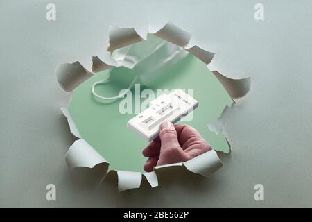 Shortage of reliable antibody tests. COVID-19 antibody test in paper hole. Hand holding test detecting antibodies to novel coronavirus SARS-CoV-2 caus Stock Photo