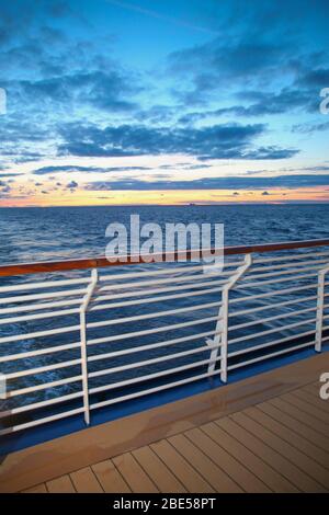 Sunset from the deck of a cruise ship across the ocean, cruising the Mediteranean Sea. Stock Photo