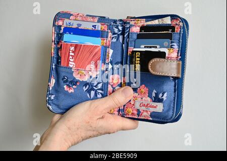 Close-up of senior woman's Cath Kidston  open purse with debit, credit and loyalty cards displayed. Stock Photo