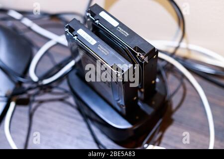 Close up of desktop computer hard drives being install in a dock station to be used with a computer to store data and information Stock Photo