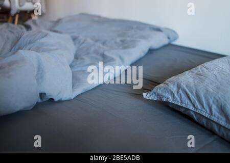 Morning bed on the bed, gray sheet, blanket and pillows Stock Photo