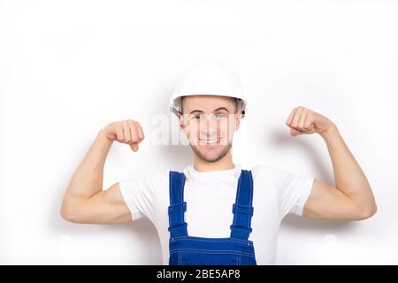 Cheerful strong guy in a helmet on a white background. Place for text Stock Photo
