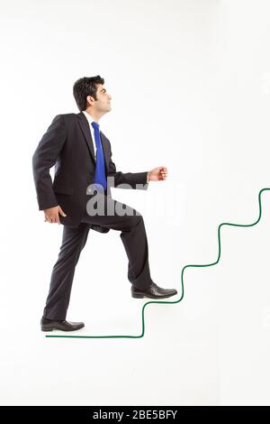 Man wearing suit climbing upward in line drawing stairs isolated on white background Stock Photo