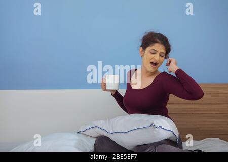 Young woman yawning while waiting for the face pack to dry. Stock Photo