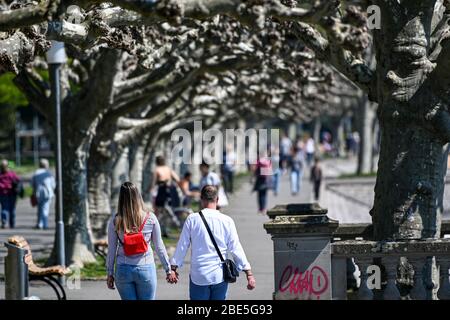 Konstanz, Germany. 12th Apr, 2020. Excursionists walk along the shore promenade of Lake Constance. Many people use the sunny weather for an Easter walk. Credit: Felix Kästle/dpa/Alamy Live News Stock Photo