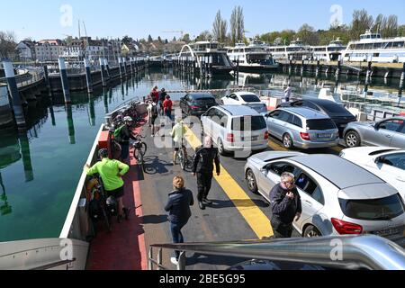 Konstanz, Germany. 12th Apr, 2020. Excursionists stand at the bow of the car ferry while it slowly drives into the ferry port. Many people use the sunny weather for an Easter walk or an excursion. Credit: Felix Kästle/dpa/Alamy Live News Stock Photo