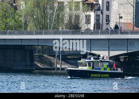 Konstanz, Germany. 12th Apr, 2020. A motorboat of the Swiss border control passes the last Rhine bridge before Lake Constance begins. Credit: Felix Kästle/dpa/Alamy Live News Stock Photo