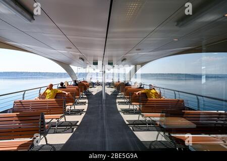 Konstanz, Germany. 12th Apr, 2020. Excursionists enjoy the beautiful weather on the deck of a ship on Lake Constance. Many people use the sunny weather for an Easter walk or an excursion. Credit: Felix Kästle/dpa/Alamy Live News Stock Photo