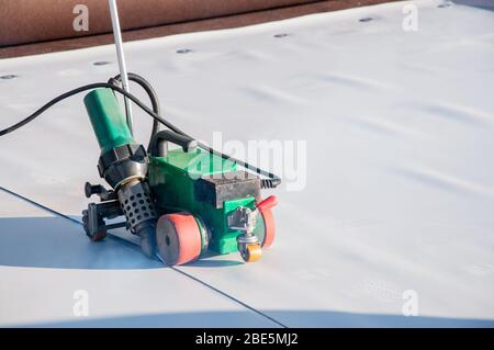 Construction device for installing waterproofing materials on the roof. Installation of waterproofing at a construction site. Protection of the roof o Stock Photo