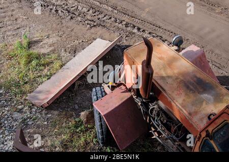 Top view on an old rusting tractor. Abandoned spent on construction equipment. Stock Photo