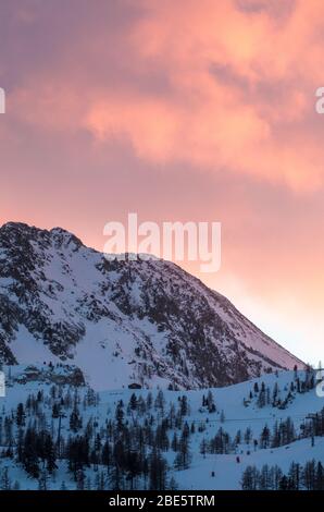 Beautiful vivid orange summer sunset over mountain top cliffs Stock Photo