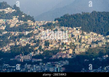 View of cluster of houses of Gangtok city nestled on mountain slope as seen from somewhere near Rumtek Monastery, Sikkim, India Stock Photo